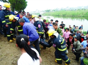 消防官兵和村民将母子二人抬上岸 通讯员 包榴栋 摄